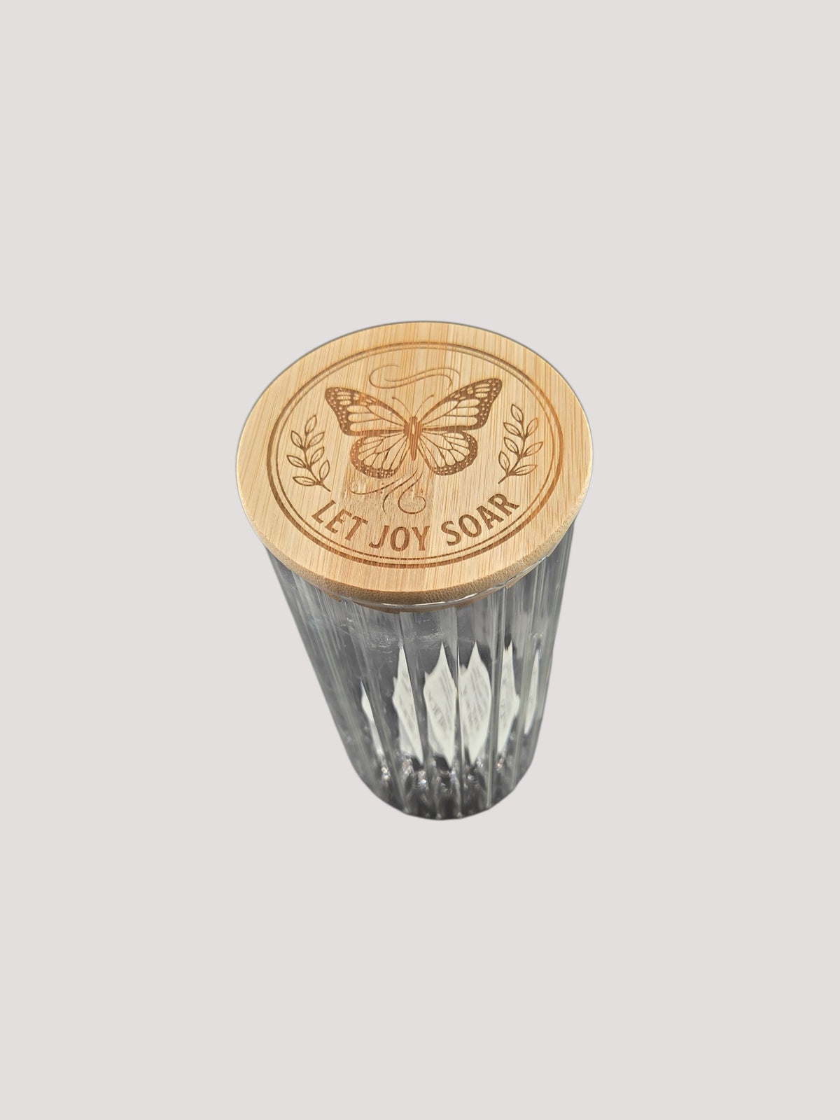 L & P Golden goods clear glass jar with a bamboo lid featuring a laser-engraved butterfly and Let Joy Soar text